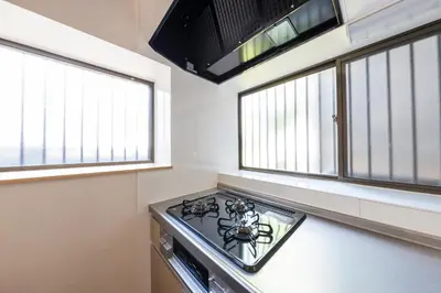 a kitchen with a stove and two windows at Sakura in Tokyo