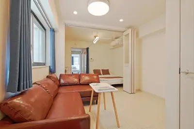 a living room with a brown leather couch and a table at V Close to Kikukawa sta 14 min to Akihabara in Tokyo