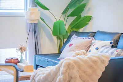 a blue couch with a blanket on it in a living room at Ikebukuro Japandi Villa in Tokyo