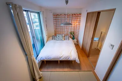 a bedroom with a bed and a large window at Ikebukuro Japandi Villa in Tokyo