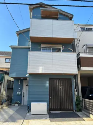 a blue house with a garage in front of it at Lapis House 101 & 201 in Tokyo