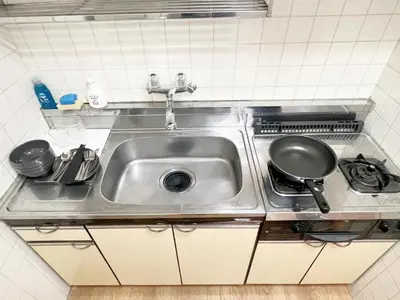 a kitchen sink with a frying pan on a stove at Takadanobaba RedH in Tokyo