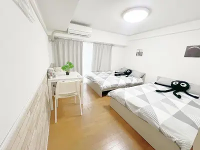 a bedroom with two beds and a desk and a table at Takadanobaba RedH in Tokyo