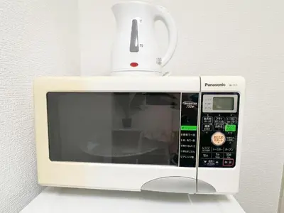 a white microwave with a cup on top of it at Takadanobaba RedH in Tokyo