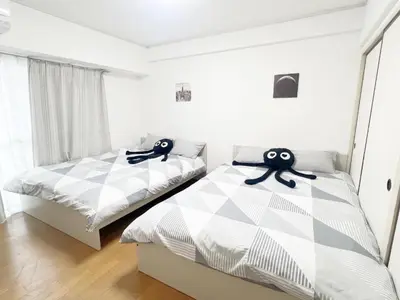 two beds in a bedroom with two monsters on them at Takadanobaba RedH in Tokyo