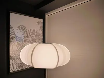 a white lamp on a wall with a picture at Triphome Asakusa Alpha 2025 in Tokyo