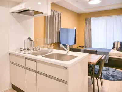 a kitchen with a sink and a room with a bed at Triphome Asakusa Alpha 2025 in Tokyo