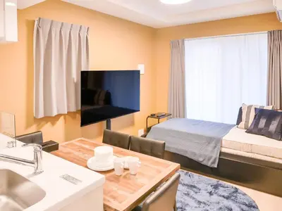 a bedroom with a bed and a desk with a sink at Triphome Asakusa Alpha 2025 in Tokyo