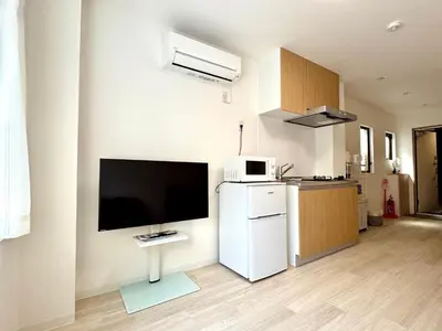 a living room with a flat screen tv on a wall at F Hotel \u65b0\u7bc9\u30a2\u30d1\u30fc\u30c8 \u8fd1\u304f\u306b\u54c1\u5ddd\u3068\u7fbd\u7530\u7a7a\u6e2f \u65e0\u6599\u99d0\u8eca\u5834\u4e88\u7d04\u5fc5\u9808 in Tokyo