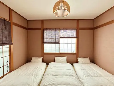 two beds in a room with two windows at F Hotel \u65b0\u7bc9\u30a2\u30d1\u30fc\u30c8 \u8fd1\u304f\u306b\u54c1\u5ddd\u3068\u7fbd\u7530\u7a7a\u6e2f \u65e0\u6599\u99d0\u8eca\u5834\u4e88\u7d04\u5fc5\u9808 in Tokyo