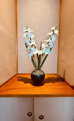 a vase filled with white and blue flowers on a shelf at F Hotel \u65b0\u7bc9\u30a2\u30d1\u30fc\u30c8 \u8fd1\u304f\u306b\u54c1\u5ddd\u3068\u7fbd\u7530\u7a7a\u6e2f \u65e0\u6599\u99d0\u8eca\u5834\u4e88\u7d04\u5fc5\u9808 in Tokyo