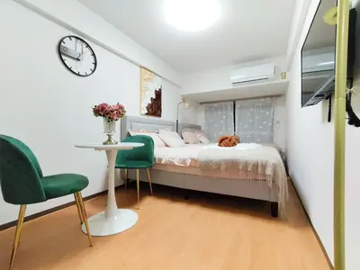 a bedroom with a bed and a table and a clock at G40\u65b0\u5bbf\u6700\u4e2d\u5fc3 \u6771\u65b0\u5bbf\u7ad95\u5206-Shinjuku center 5 mins to Station, Max 4 \u76f4\u8fbe\u65b0\u5bbf \u6d89\u8c37 \u8868\u53c2\u9053 \u6c60\u888b \u4e0a\u91ce \u4ee3\u4ee3\u6728 \u94f6\u5ea7 \u539f\u5bbf in Tokyo