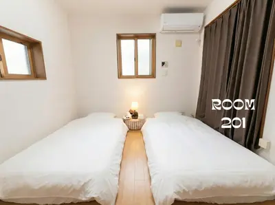 two twin beds in a room with a window at MEME Villa 5BR - 3 Separate Toilets & 3 Showers - 10Gbps Wifi in Tokyo