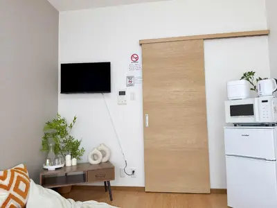 a living room with a door with a microwave at \u685c\u306e\u5ddd \u6c60\u888b\u99c5 7\u5206 2-5\u4eba\u4e28Ikebukuro JR Line 7 minutes 2-5 people in Tokyo