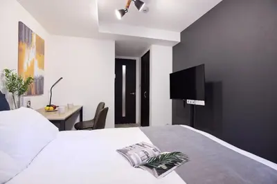 a bedroom with a white bed and a desk at \u30e1\u30be\u30f3\u30cf\u30a4\u30a6\u30a7\u30a4\u6c60\u888b in Tokyo