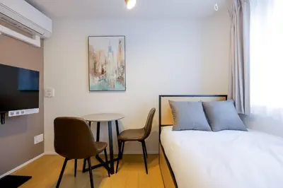 a bedroom with a bed and a table and chairs at \u30ea\u30d0\u30c6\u30a3 in Tokyo
