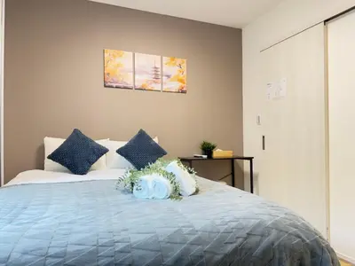 a bedroom with a bed with blue and white pillows at Ikebukuro Area 2 Units 2122 KamiikeApartment in Tokyo