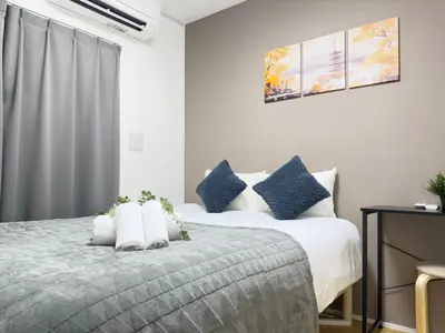 a bedroom with a bed with blue and white pillows at Ikebukuro Area 2 Units 2122 KamiikeApartment in Tokyo