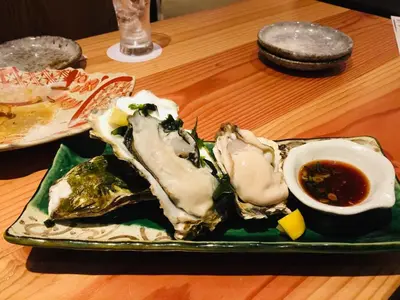 a plate of oysters and a egg on a table at Maison Okuasakusa in Tokyo