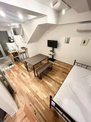a room with a table and a couch and a bed at Yotsugi Hotel Asakusa Skytree in Tokyo