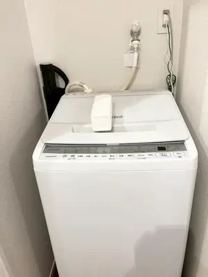 a washer and dryer with a phone on top of it at Yotsugi Hotel Asakusa Skytree in Tokyo