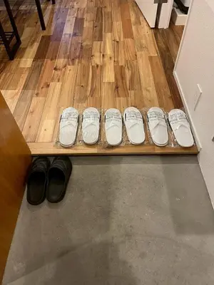 a row of white shoes sitting on a wooden bench at Yotsugi Hotel Asakusa Skytree in Tokyo