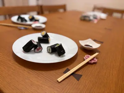 a plate of food on a wooden table with chopsticks at Tokyo Bauhaus in Tokyo