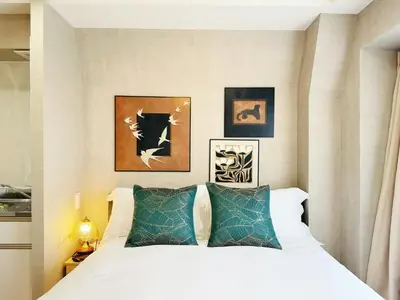 a bedroom with a white bed with two green pillows at Tokyo Hakusan Louis Apartment near TOKYO DOME close to Yamanote Line in Tokyo