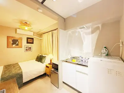 a hotel room with a bed and a sink and a kitchen at Tokyo Hakusan Louis Apartment near TOKYO DOME close to Yamanote Line in Tokyo
