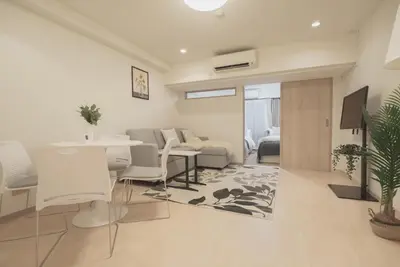 a living room with a table and chairs and a couch at 1 minute from Higashi-Shinjuku Station Large living room in Tokyo
