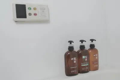 a group of four bottles of water next to a control panel at 1 minute from Higashi-Shinjuku Station Large living room in Tokyo