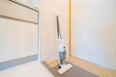 a hair dryer in the corner of a room at 1 minute from Higashi-Shinjuku Station Large living room in Tokyo