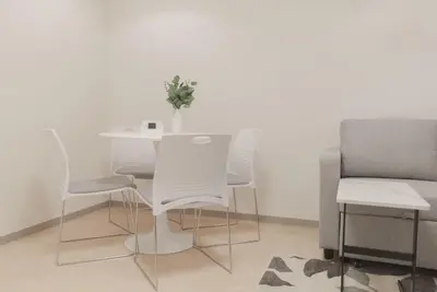a white table and chairs with a vase on it at 1 minute from Higashi-Shinjuku Station Large living room in Tokyo