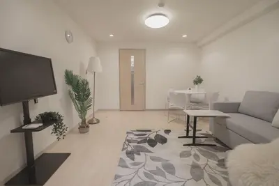 a living room with a couch and a flat screen tv at 1 minute from Higashi-Shinjuku Station Large living room in Tokyo