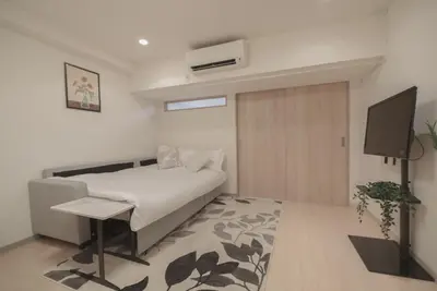 a bedroom with a bed and a tv in it at 1 minute from Higashi-Shinjuku Station Large living room in Tokyo