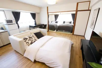 a living room with a white couch and a mirror at \u5bdb\u6c38\u5bfa\u5742\u30cf\u30a4\u30e0 803 \u6771\u4eac\u89b3\u5149\u306e\u62e0\u70b9\u306b\u6700\u9069 \u9daf\u8c37\u99c52\u5206 in Tokyo