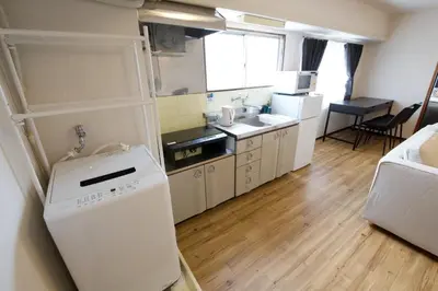 a small kitchen with a refrigerator and a sink at \u5bdb\u6c38\u5bfa\u5742\u30cf\u30a4\u30e0 803 \u6771\u4eac\u89b3\u5149\u306e\u62e0\u70b9\u306b\u6700\u9069 \u9daf\u8c37\u99c52\u5206 in Tokyo