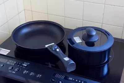 a pot sitting on top of a stove with a remote control at \u5bdb\u6c38\u5bfa\u5742\u30cf\u30a4\u30e0 803 \u6771\u4eac\u89b3\u5149\u306e\u62e0\u70b9\u306b\u6700\u9069 \u9daf\u8c37\u99c52\u5206 in Tokyo