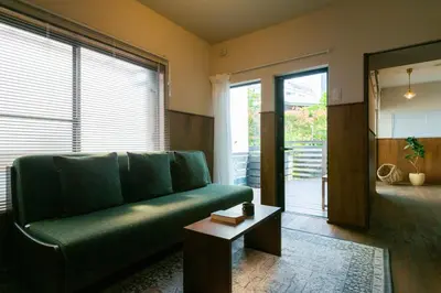 a living room with a green couch and a table at HOTEL RIN TOKYO - Private Townhouse - in Tokyo