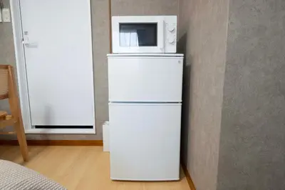 a white refrigerator with a microwave on top of it at All Good Stay HEIWAJIMA in Tokyo