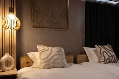 a bedroom with two beds with a lamp and a pillow at All Good Stay HEIWAJIMA in Tokyo