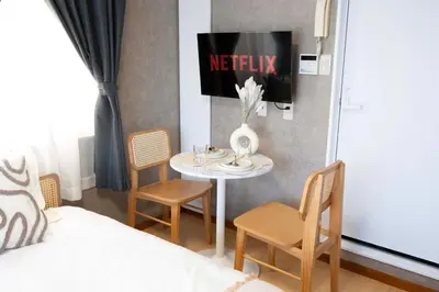 a room with a table and chairs and a bed at All Good Stay HEIWAJIMA in Tokyo