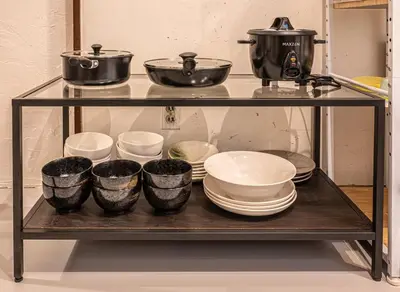 a shelf with dishes and pots and pans on it at t plus house ryogoku in Tokyo