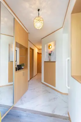 a hallway with a large white marble floor and a chandelier at Five Roses House in Tokyo