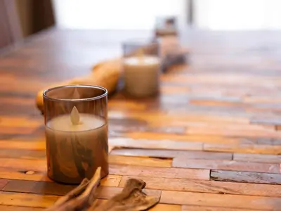 two candles sitting on top of a wooden table at Five Roses House in Tokyo