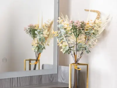 a vase with flowers in it in front of a mirror at Five Roses House in Tokyo