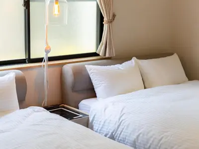 a hotel room with two beds and a window at Five Roses House in Tokyo