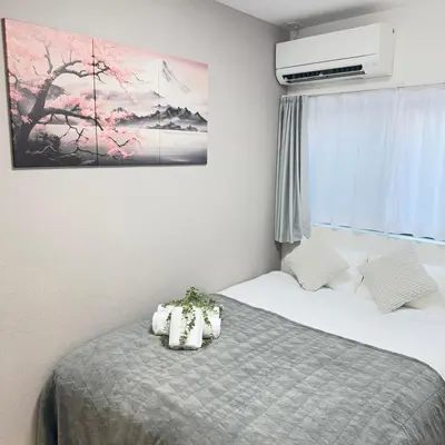 a bedroom with two beds and a painting on the wall at Ikebukuro Area 1F3 KamiikeApartment in Tokyo