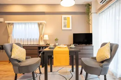 a living room with a table and chairs and a television at Nestry Asakusa 403\u53f7\u5ba4 in Tokyo