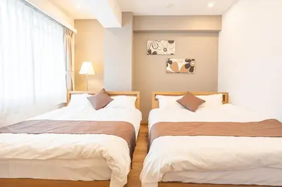 two beds in a bedroom with a window at Nestry Asakusa 403\u53f7\u5ba4 in Tokyo